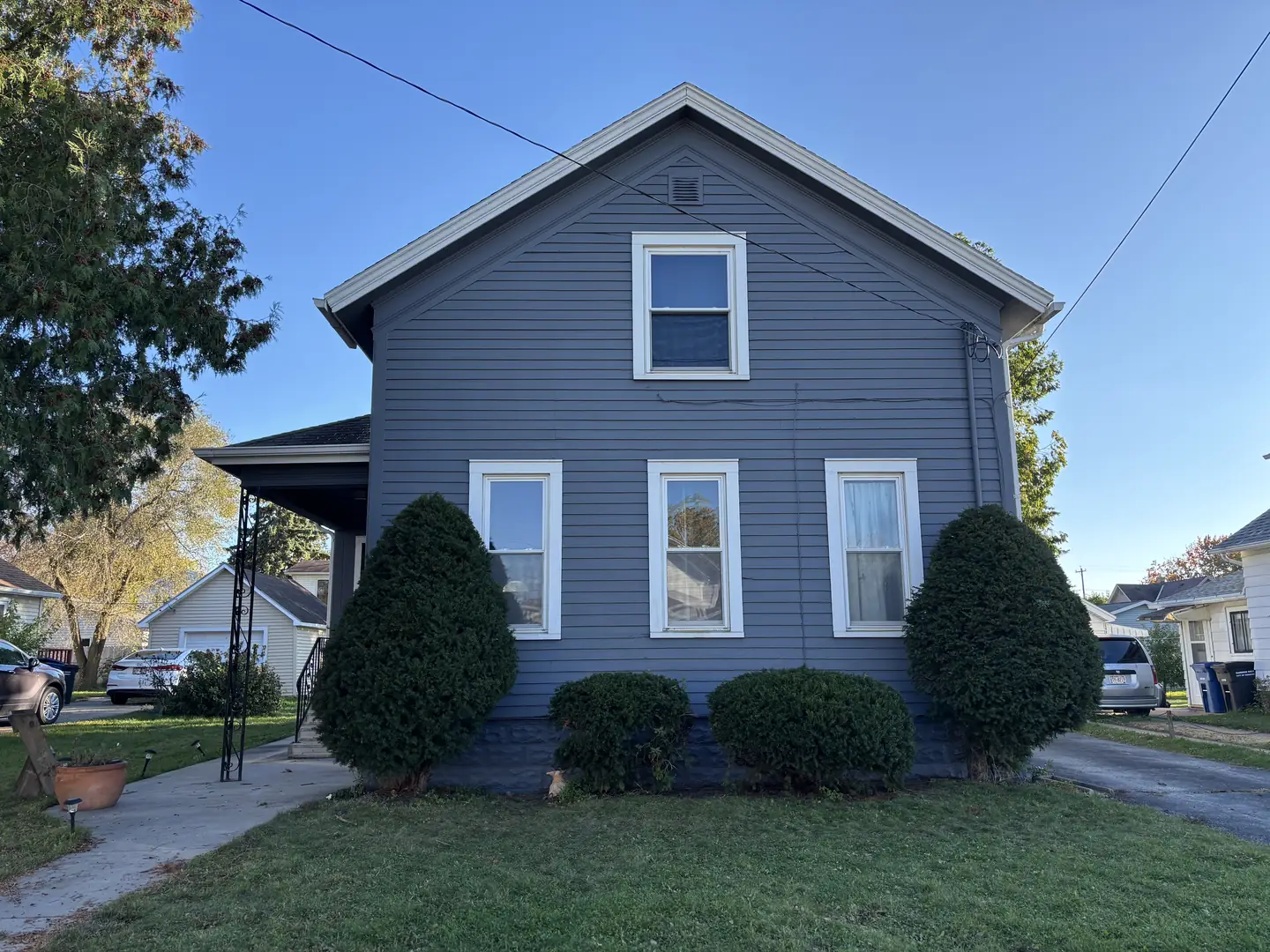 A two-story home finished in slate gray with white trim